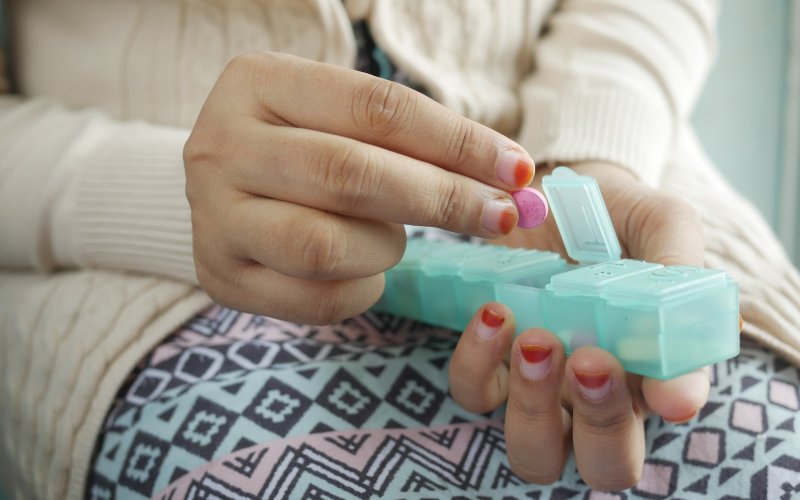 person holding white and green plastic container